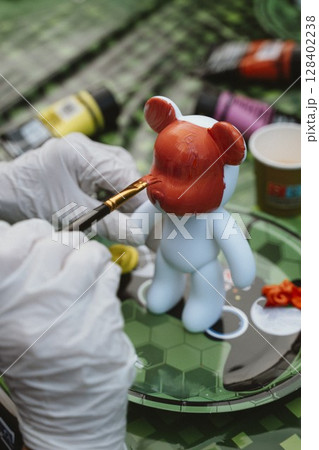 Painting a Toy Figure with Bright Colors 128402238