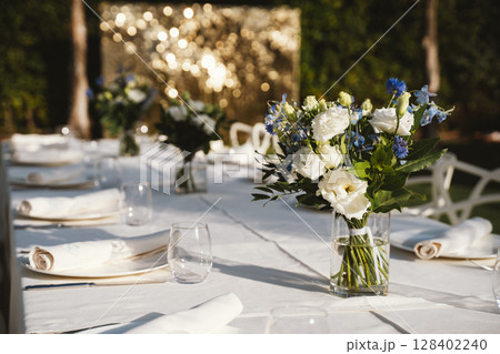 Elegant Outdoor Table Setting with Floral Arrangements Elegant Outdoor Table Setting with Floral Arrangements 128402240