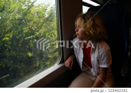 Child Gazing Out Train Window Capturing Serenity Child Gazing Out Train Window Capturing Serenity 128402281