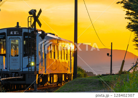 夕焼け光芒に映える田園を走る鉄道列車風景　(見晴台駅)(南阿蘇村) 128402307