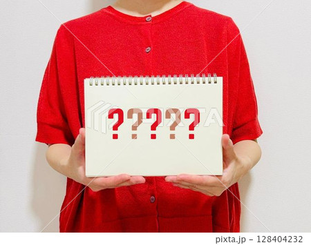 はてなマークが書かれたノートを持つ女性 128404232