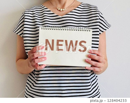 NEWSと書かれたノートを持つ女性 NEWSと書かれたノートを持つ女性 128404233