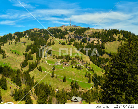 Scenic view of rolling hills and lush greenery in a mountainous region with clear skies 128404813