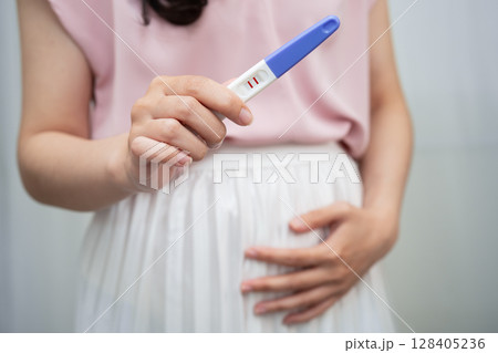 Asian holding pregnancy test for female of ovulation day, fetus, maternity, childbirth, birth control. Asian holding pregnancy test for female of ovulation day, fetus, maternity, childbirth, birth control. 128405236