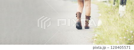 Banner Woman traveller walking on road relaxation. Women wear sneaker shoes walking summer park. Females standing green park on forest pathway outdoors. Traveler relaxing walk way with copy space Banner Woman traveller walking on road relaxation. Women wear sneaker shoes walking summer park. Females standing green park on forest pathway outdoors. Traveler relaxing walk way with copy space 128405571
