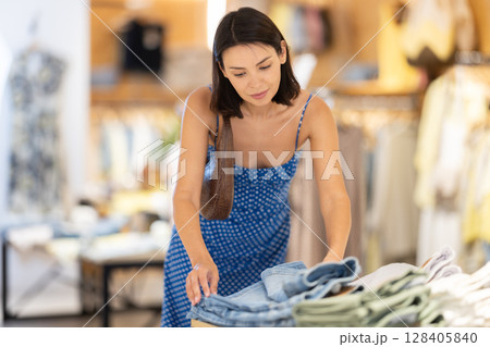 Adult woman choosing shorts in clothing store Adult woman choosing shorts in clothing store 128405840