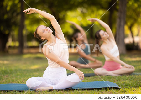 Group of young women doing yoga in lotus pose Group of young women doing yoga in lotus pose 128406050