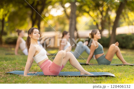 Group of young women doing stretching in park Group of young women doing stretching in park 128406132