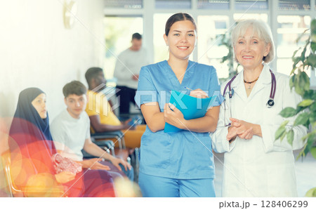 Elderly and young female medics making notes 128406299