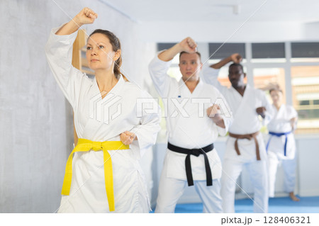 Multinational students repeat position and perform sequence of punches and painful techniques kata Multinational students repeat position and perform sequence of punches and painful techniques kata 128406321
