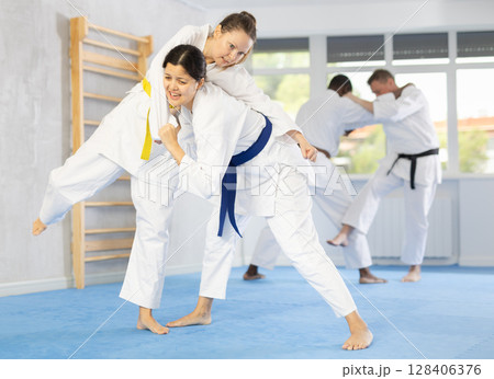 Multinational athletes in pair conduct training battle in oriental fighting technique Multinational athletes in pair conduct training battle in oriental fighting technique 128406376