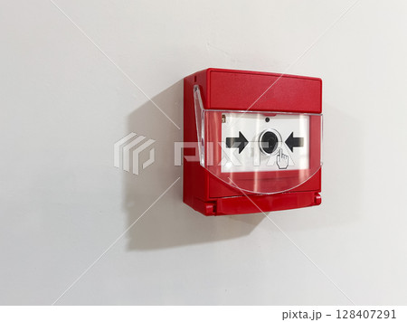 Red fire alarm on a white wall for emergency alert system. 128407291