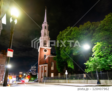 Park Street Church in Boston, Massachusetts, United States stands brightly lit at a quiet downtown intersection 128407962