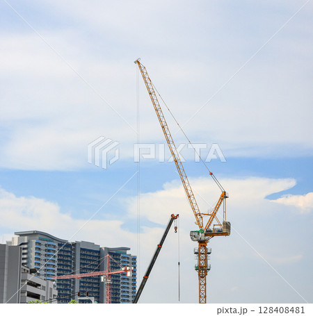construction tower crane work with construction worker on top of building, used in construction site with blue sky. 128408481