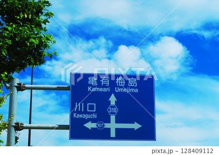 亀有梅島川口の方向を表示した道路標識と青空の風景 亀有梅島川口の方向を表示した道路標識と青空の風景 128409112