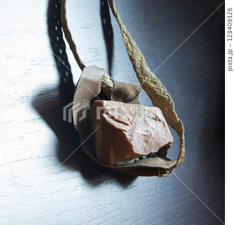 Sling with stone on wooden background 128409326