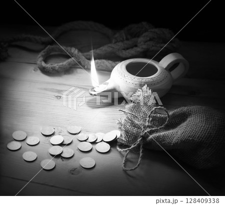 An oil lamp and silver coins An oil lamp and silver coins 128409338