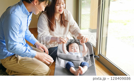部屋で赤ちゃんをあやすカップル 部屋で赤ちゃんをあやすカップル 128409886