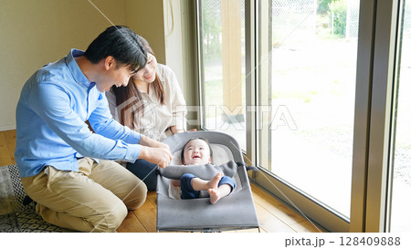 部屋で赤ちゃんをあやすカップル 部屋で赤ちゃんをあやすカップル 128409888
