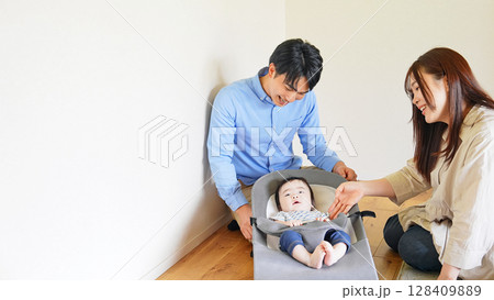 部屋で赤ちゃんをあやすカップル 128409889