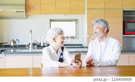 一緒にスマホを見るシニアカップル 128409909