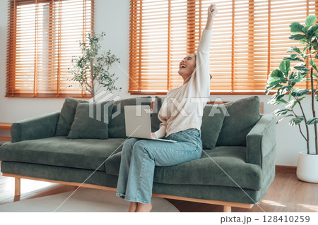 Funny euphoric young asian woman celebrating winning 128410259
