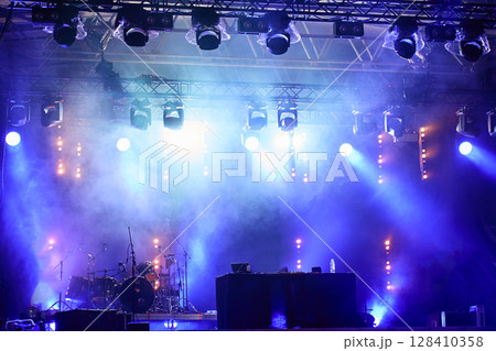 Empty stage with bright concert lighting, spotlights and smoke effects prepared for live music event 128410358