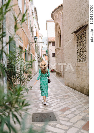 Young woman in beautiful dress walking in the street of the city. Eurotrip. Travel, tourism. Fashion Young woman in beautiful dress walking in the street of the city. Eurotrip. Travel, tourism. Fashion 128410700