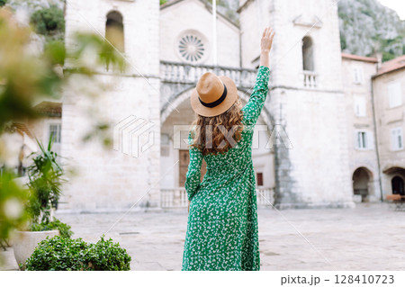 Happy female tourist in beautiful dress walking in the street of the city. Fashion style. Travel. 128410723