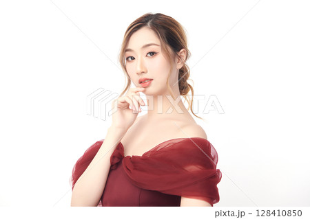 A beautiful young Asian woman with clean, fresh skin against a white background. Skincare, facial treatment, cosmetology, beauty, and spa. An elegant portrait of an Asian woman. 128410850