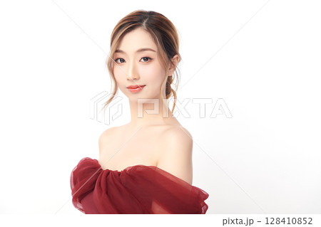 A beautiful young Asian woman with clean, fresh skin against a white background. Skincare, facial treatment, cosmetology, beauty, and spa. An elegant portrait of an Asian woman. 128410852