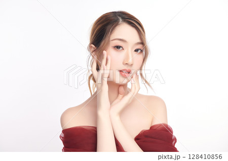 A beautiful young Asian woman with clean, fresh skin against a white background. Skincare, facial treatment, cosmetology, beauty, and spa. An elegant portrait of an Asian woman. A beautiful young Asian woman with clean, fresh skin against a white background. Skincare, facial treatment, cosmetology, beauty, and spa. An elegant portrait of an Asian woman. 128410856