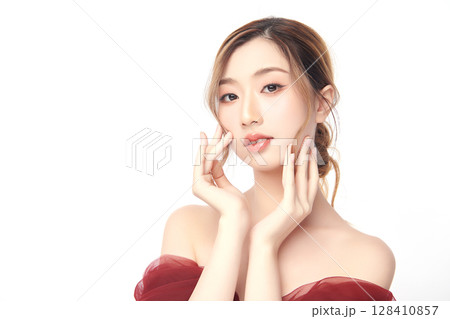 A beautiful young Asian woman with clean, fresh skin against a white background. Skincare, facial treatment, cosmetology, beauty, and spa. An elegant portrait of an Asian woman. 128410857