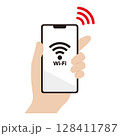 Wi-Fiに接続されたスマートフォンを持つ手のイラスト素材 128411787