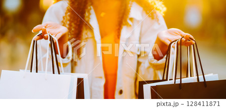 Young woman with shopping bags walking on street. Female coming from a sale downtown Young woman with shopping bags walking on street. Female coming from a sale downtown 128411871