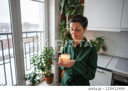 Joyful woman enjoying candlelight, aromatherapy self care. Stress relief, emotional wellbeing Joyful woman enjoying candlelight, aromatherapy self care. Stress relief, emotional wellbeing 128412404