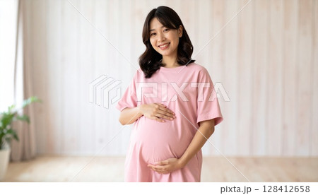 幸せそうなピンクの服の妊婦のポートレート 128412658