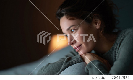 Thoughtful woman gazing, lost in contemplation. Reflective mood in soft light, conveying peace and introspection. Great for mental health or lifestyle themes. Thoughtful woman gazing, lost in contemplation. Reflective mood in soft light, conveying peace and introspection. Great for mental health or lifestyle themes. 128412926