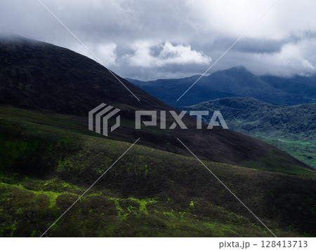Overcast day at Coomloughra Horseshoe viewing green mountains and cloudy skies over County Kerry, Ireland. 128413713