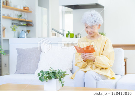 リビングで年金手帳を見るシニアの女性 128413810