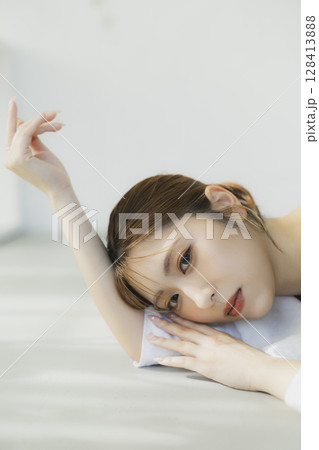 床に寝転ぶ女性 128413888