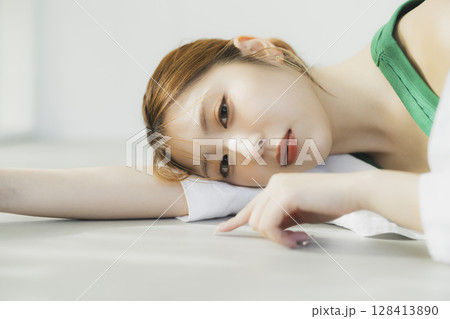 床に寝転ぶ女性 128413890