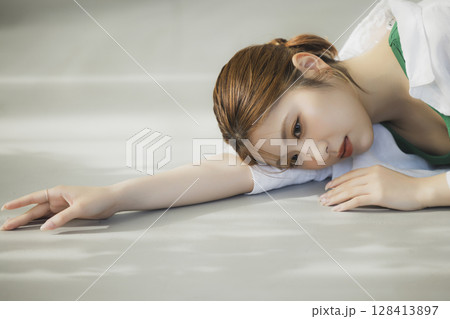 床に寝転ぶ女性 128413897