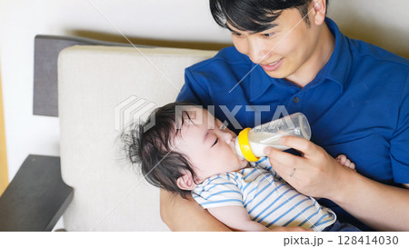 赤ちゃんに哺乳瓶でミルクを飲ませる男性 128414030