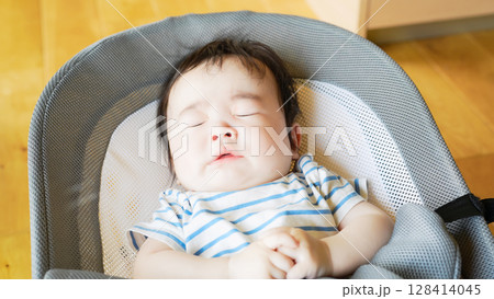 ゆりかごで寝ながらくしゃみする赤ちゃん 128414045