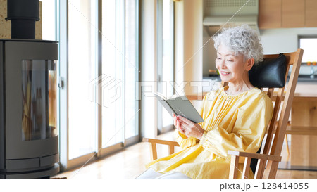 室内で読書するシニア女性 室内で読書するシニア女性 128414055
