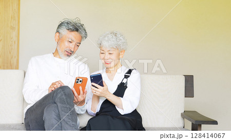 一緒にスマホを見るシニアカップル 128414067