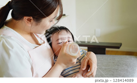 赤ちゃんに哺乳瓶でミルクを飲ませる女性 128414089