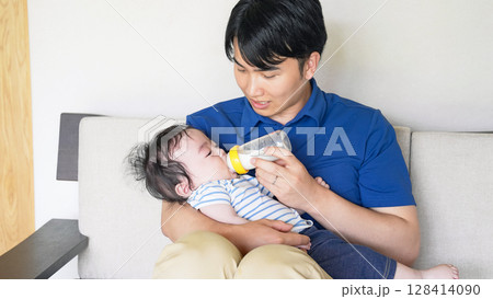 赤ちゃんに哺乳瓶でミルクを飲ませる男性 128414090