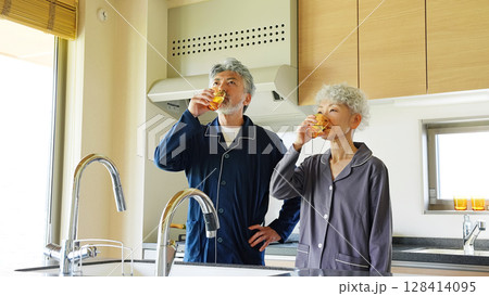 キッチンで水を飲むシニアカップル 128414095